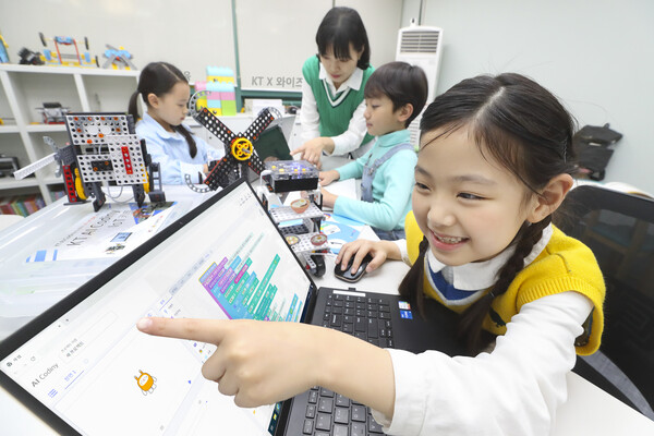 ▲선생님이 어린 학생들에게 KT AI 코디니를 이용해 코딩과 하드웨어 융합 교육을 진행하고 있다.